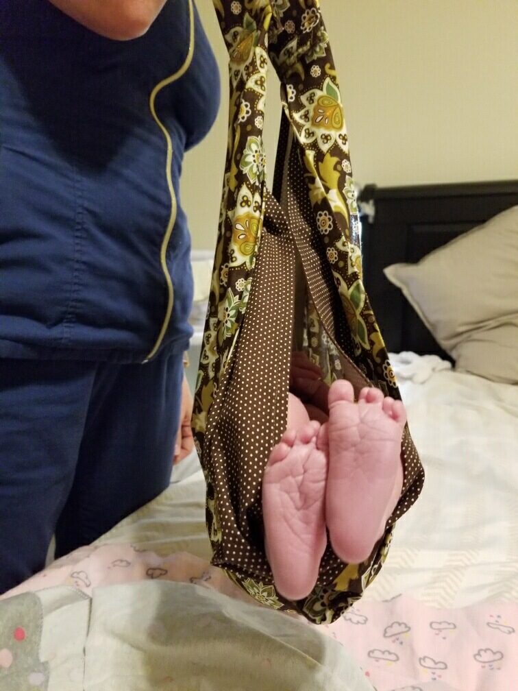 Newborn feet in a sling during a home visit